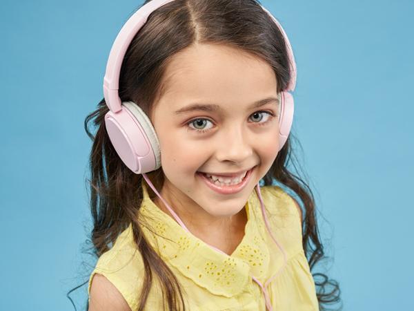 uśmiechnięte dziecko ze słuchawkami na uszach 